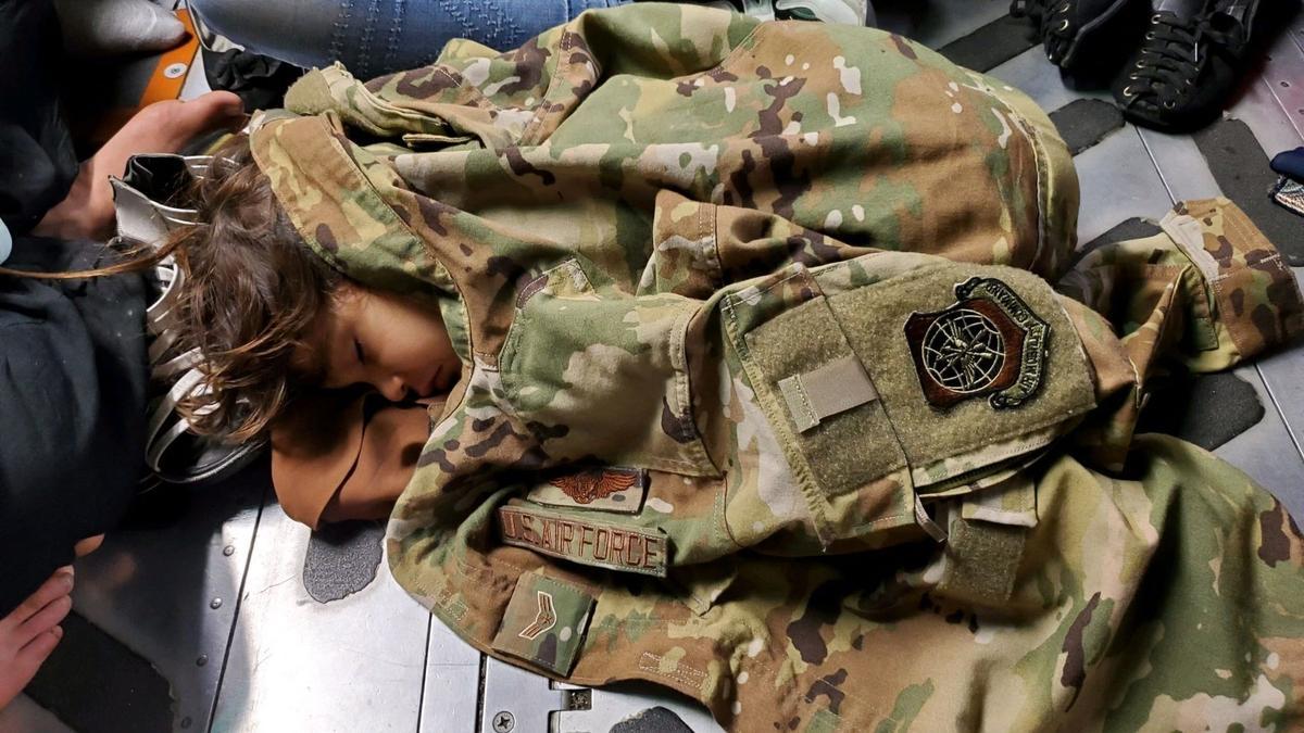 Un niño afgano duerme en el suelo de carga de un C-17 Globemaster III de la Fuerza Aérea de EE. UU.
