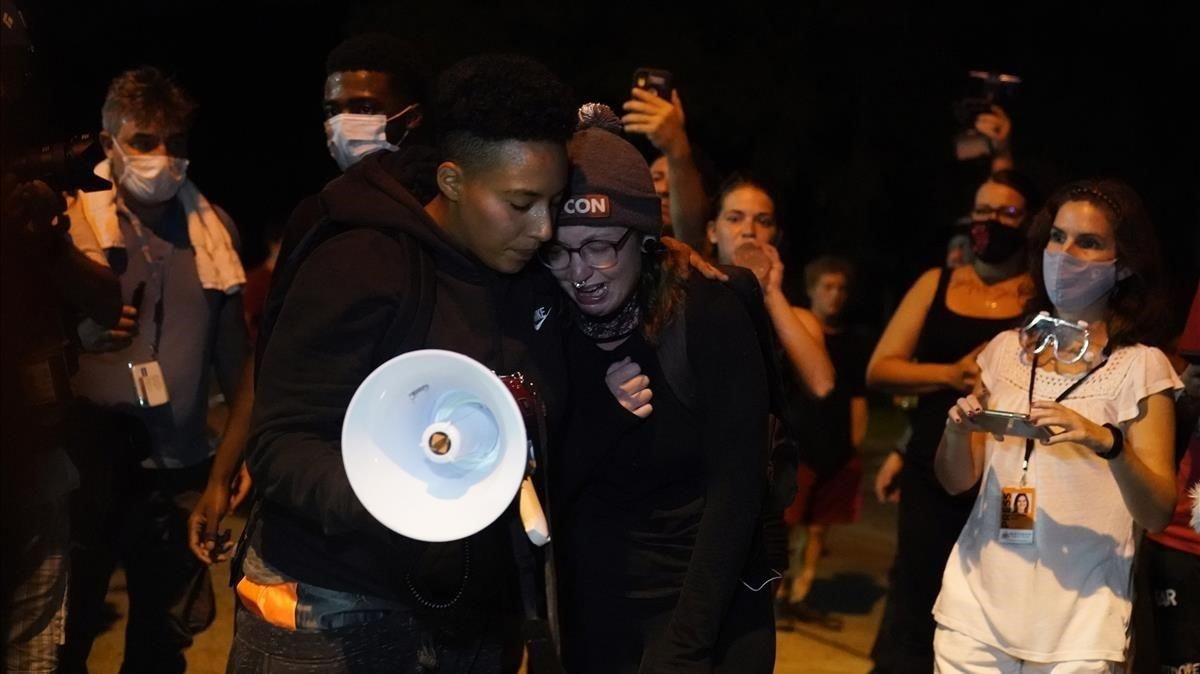 Dos manifestantes lloran en la manifestación de repulsa por los dos hombres muertos por disparos la noche del martes en Kenosha. Dos manifestantes lloran en la manifestación de repulsa por los dos hombres muertos por disparos la noche del martes en Kenosha.