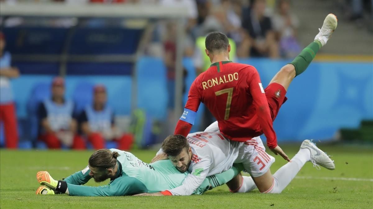 Cristiano Ronaldo cae sobre Piqué y De Gea. Cristiano Ronaldo cae sobre Piqué y De Gea.