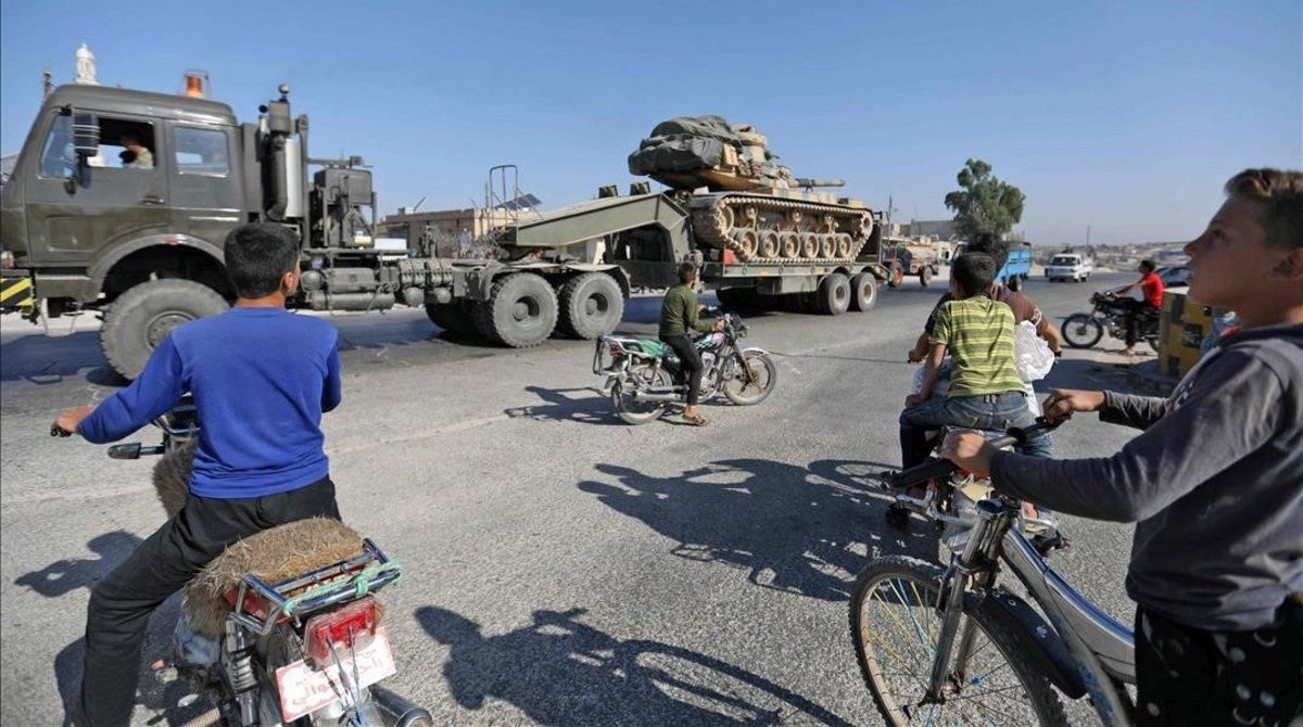 Los niños de Maaret al-Numan, en la provincia de Idlib, en el norte de Siria, observan cómo un vehículo transporta un tanque turco que, según los informes, parte del convoy de vehículos militares se dirige hacia la ciudad de Khan Sheikhun, en el sur de la provincia, el 19 de agosto de 2019 Los niños de Maaret al-Numan, en la provincia de Idlib, en el norte de Siria, observan cómo un vehículo transporta un tanque turco que, según los informes, parte del convoy de vehículos militares se dirige hacia la ciudad de Khan Sheikhun, en el sur de la provincia, el 19 de agosto de 2019