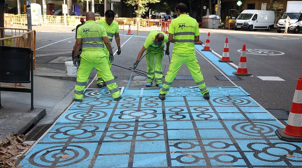 Un grupo de operarios pintan parte de la calzada de la calle de Rocafort de Barcelona para ampliar el espacio destinado a los peatones, el pasado 2 de julio. Un grupo de operarios pintan parte de la calzada de la calle de Rocafort de Barcelona para ampliar el espacio destinado a los peatones, el pasado 2 de julio.