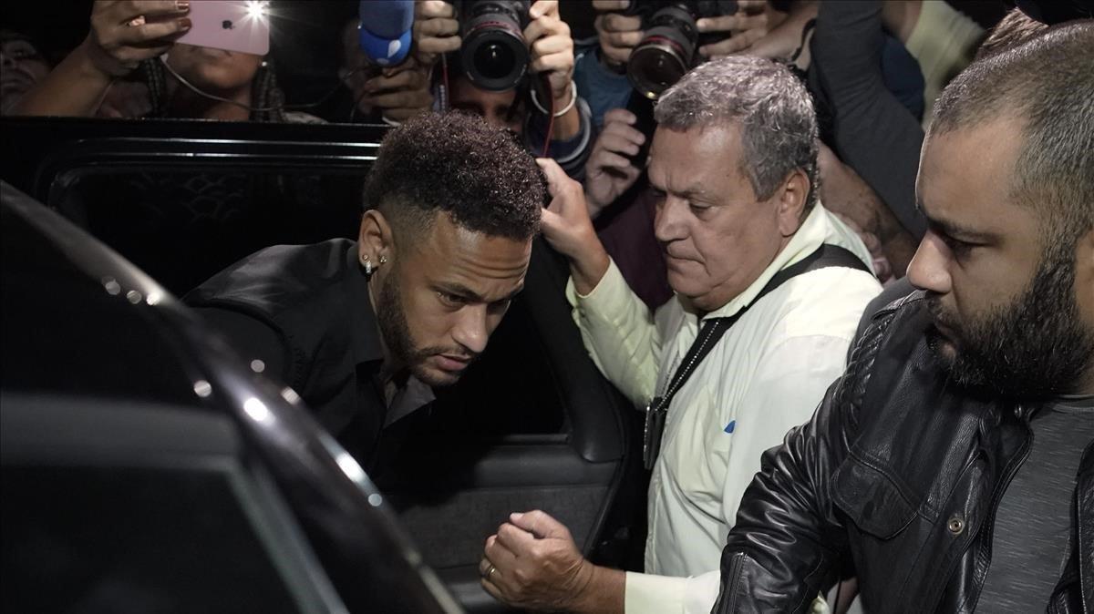 Neymar protegido a la salida de la comisaría de Sao Paulo tras ser interrogado por la policía brasileña por la acusación de violación en junio del 2019. 