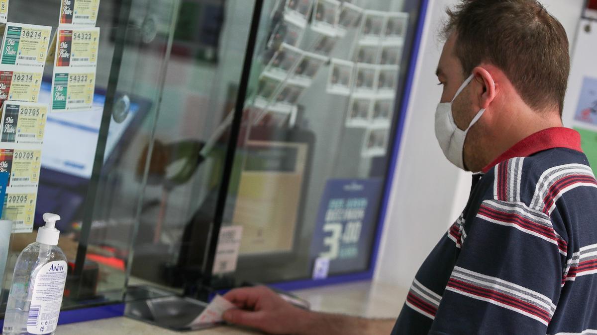 Un hombre compra lotería en una Administración en Manises (Valencia), en mayo de hace dos años.