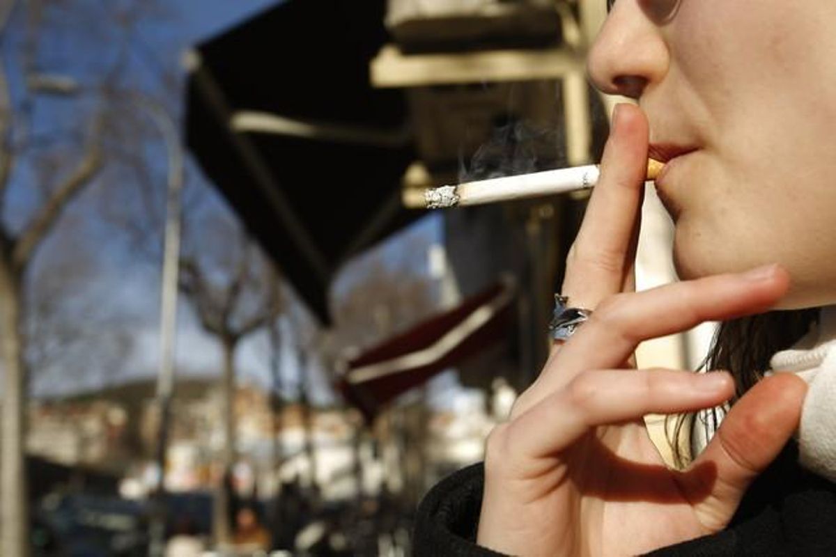 Una mujer fuma en la calle. Una mujer fuma en la calle.