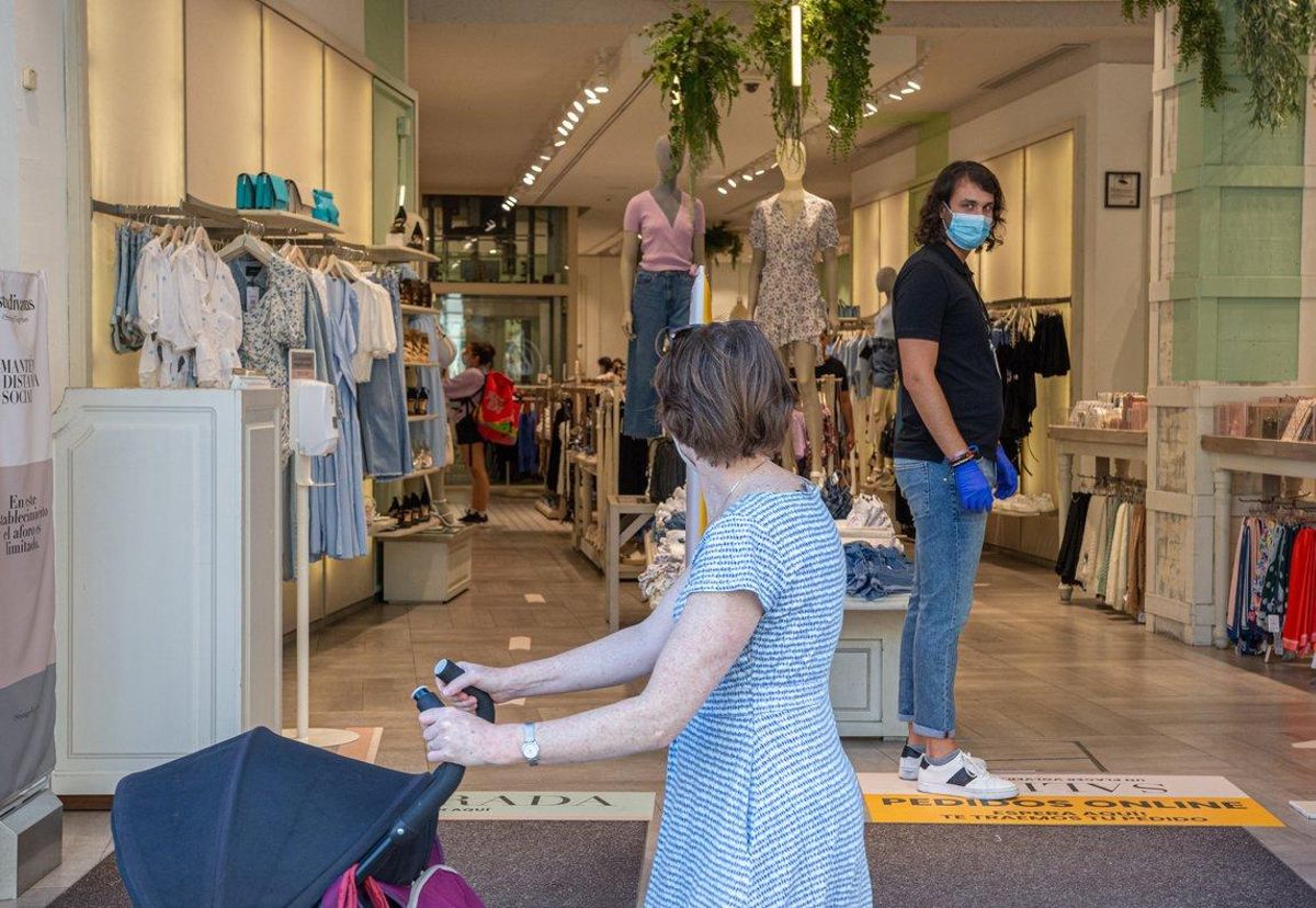 Clientela pasa frente a una tienda abierta en Barcelona. Clientela pasa frente a una tienda abierta en Barcelona.