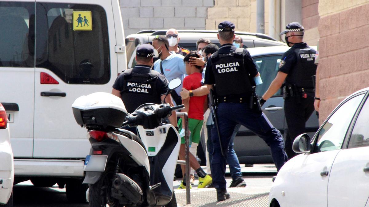 Autoridades de Ceuta meten en un furgón a uno de los menores migrantes no acompañados repatriados a Marruecos el pasado 13 de agosto.