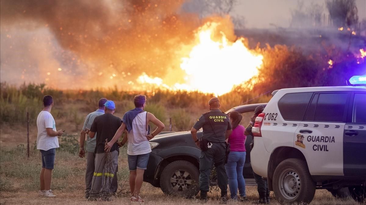 Vecinos observan el incendio forestal declarado en el Paraje Olivargas de Almonaster la Real (Huelva). Vecinos observan el incendio forestal declarado en el Paraje Olivargas de Almonaster la Real (Huelva).
