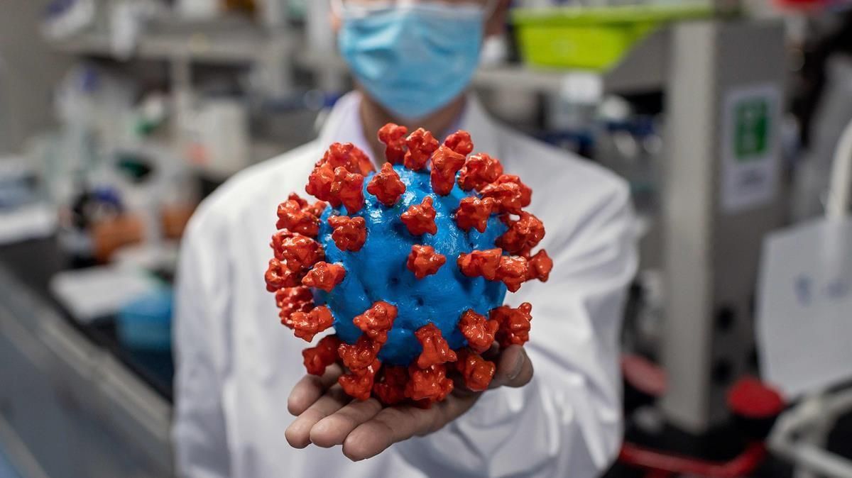 Un científico sostiene una maqueta del coronavirus SARS-CoV-2, el patógeno responsable de la pandemia de covid-19. Un científico sostiene una maqueta del coronavirus SARS-CoV-2, el patógeno responsable de la pandemia de covid-19.