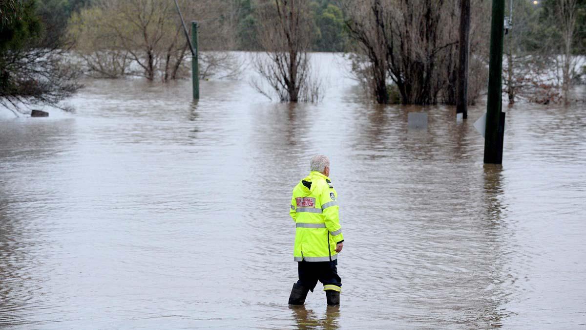 Un trabajador de rescate examina un área inundada debido a la lluvia torrencial en el suburbio de Camden en Sydney.