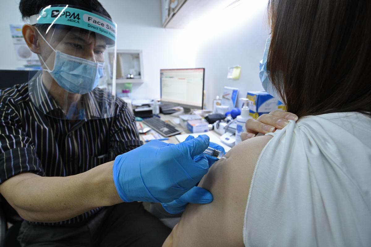 Un sanitario pone una vacuna en Singapur.