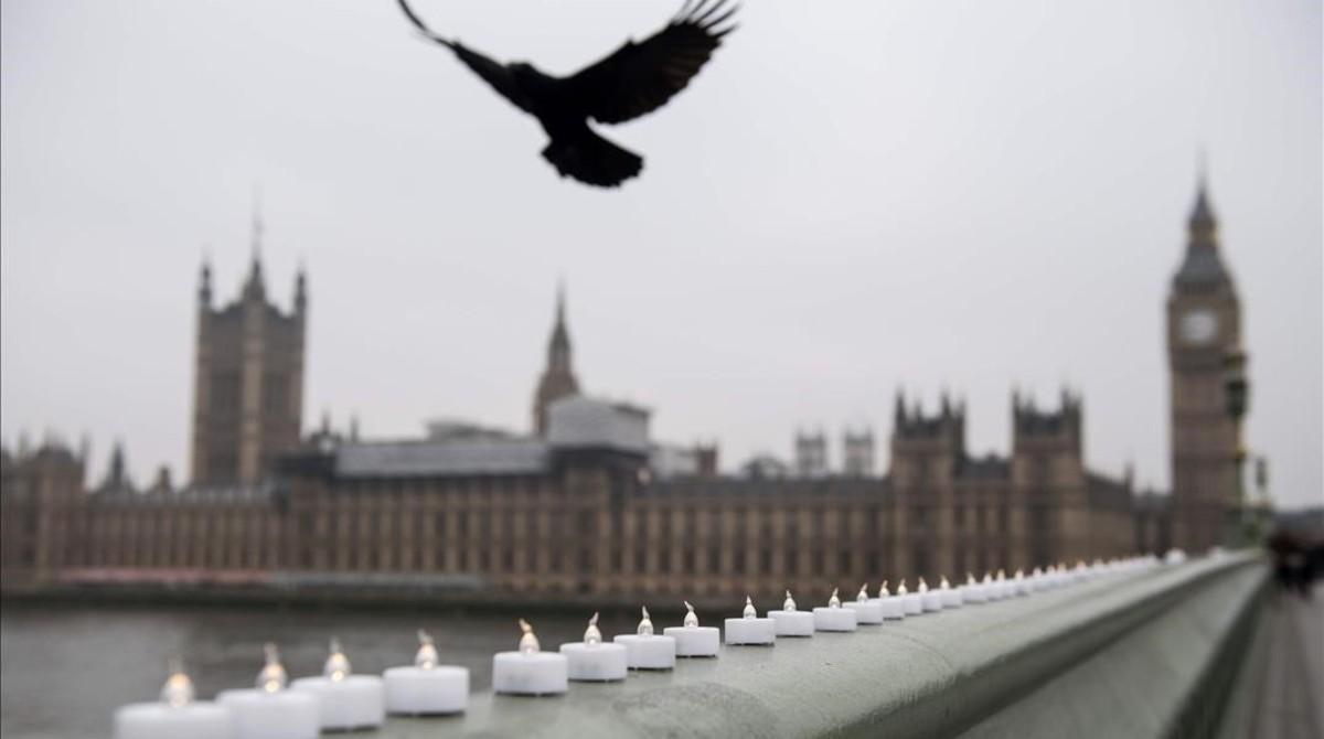 Un pájaro sobrevuela unas velas electrónicas en homenaje a las víctimas del atentado de Londres.
