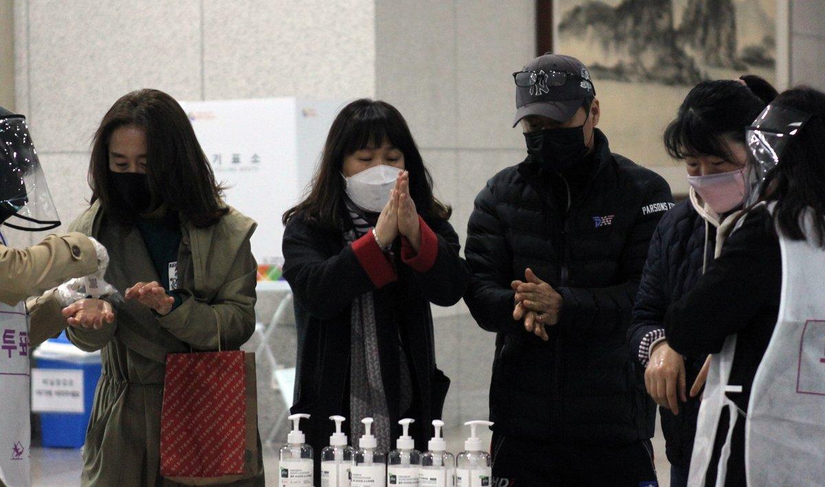 Ciudadanos se desinfectan las manos antes de votar en las elecciones que se celebran en Corea del Sur.