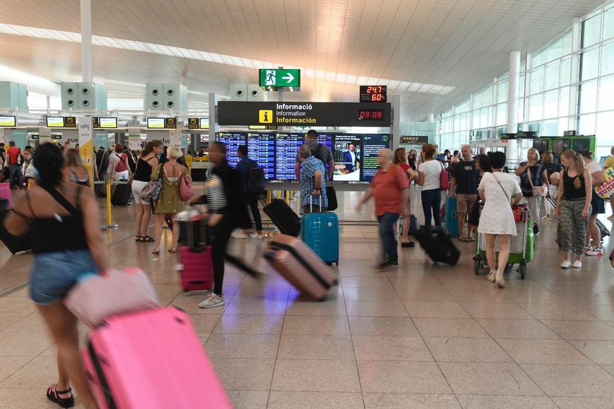 Pasajeros, en el aeropuerto de Barcelona-El Prat, en el primer día de huelga del personal de tierra de Iberia a finales de julio. 