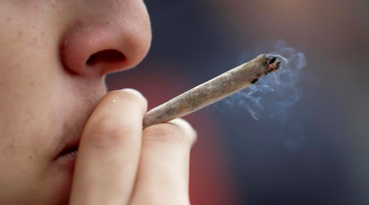 Un joven fuma un porro Un joven fuma un porro