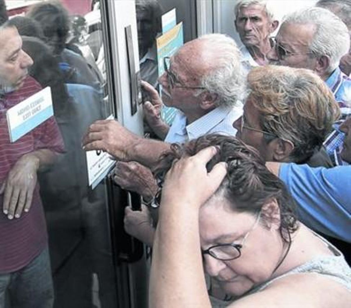 Un grupo de pensionisas espera ante la puerta de un banco en Creta. Un grupo de pensionisas espera ante la puerta de un banco en Creta.