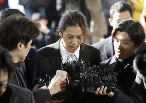 El cantante Jung Joon-young, en el centro, al llegar a la comisaría central de Seúl, el pasado marzo.