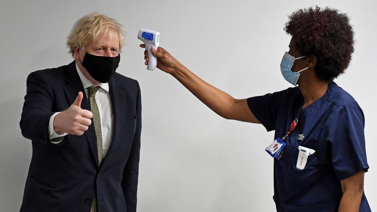 Una mujer toma la temperatura al primer ministro Boris Johnson Una mujer toma la temperatura al primer ministro Boris Johnson