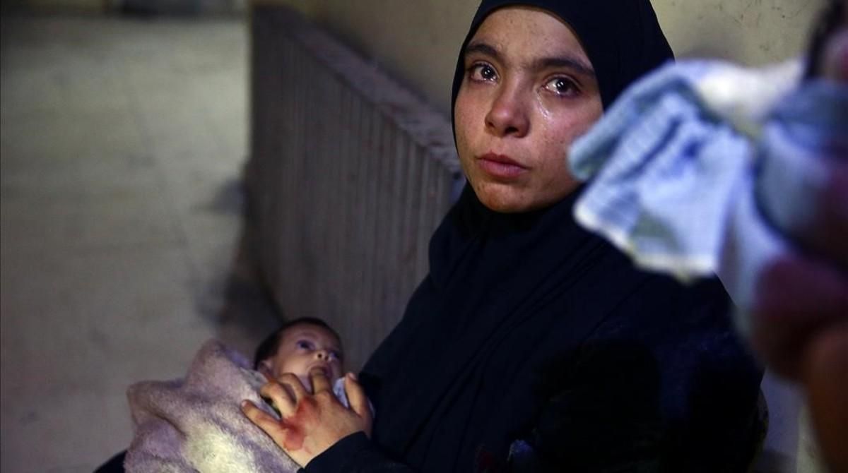 Heba Hamuri coloca su dedo en la boca de su bebé hambrienta en un centro médico en el Duma (este de Guta) el pasado 8 de enero. Heba Hamuri coloca su dedo en la boca de su bebé hambrienta en un centro médico en el Duma (este de Guta) el pasado 8 de enero.