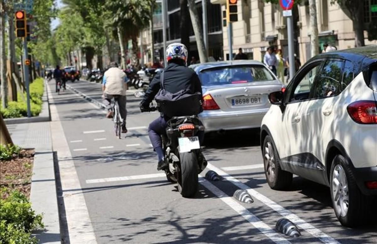 Una moto intenta alcanzar el semáforo por el carril bici. Una moto intenta alcanzar el semáforo por el carril bici.