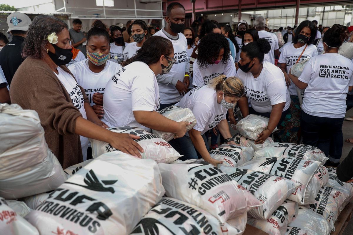Un grupo de vecinos gestionan la recepción de alimentos donados en una favela. Un grupo de vecinos gestionan la recepción de alimentos donados en una favela.