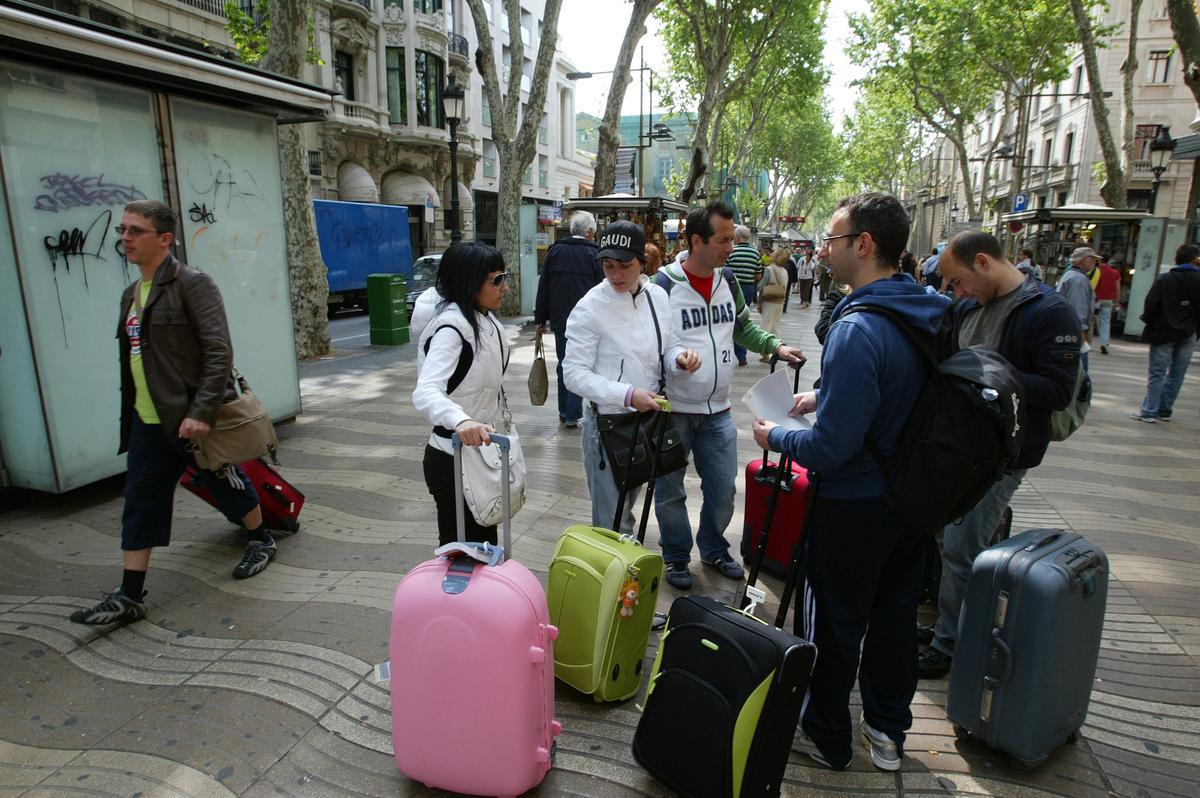 Turistas con maletas en la Rambla de Barcelona.