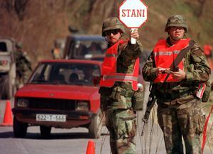 Soldados norteamericanos de la misión OTAN SFOR regulan el tráfico en una carretera serbobosnia en junio de 2002.