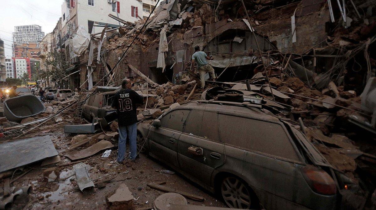 Varios vecinos inspeccionan los restos de un edificio arrasado por la explosión, en Beirut, este miércoles 5 de agosto.