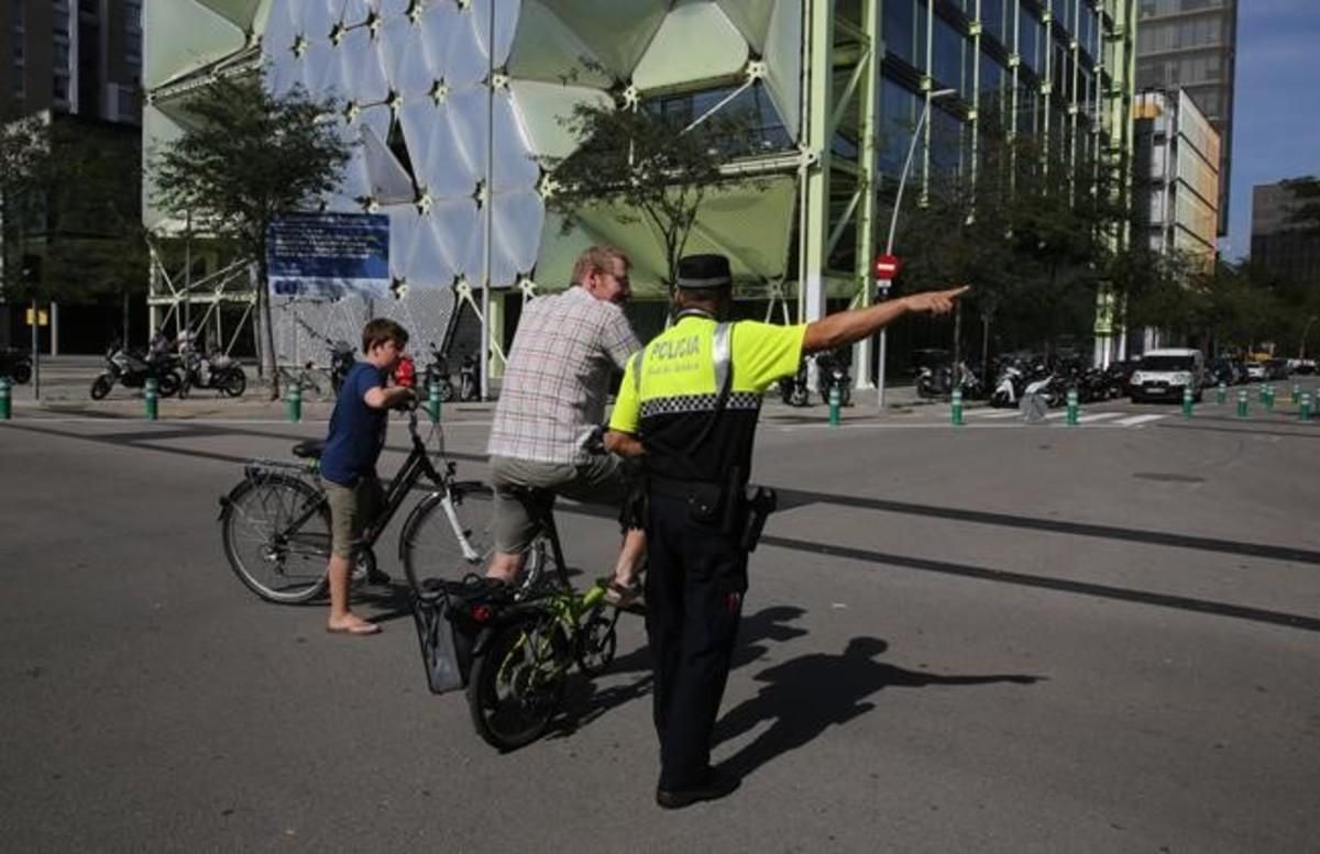 Un policía orienta a un padre y a su hijo, residentes en la zona, sobre la circulación por la supermanzana de Sant Martí. Un policía orienta a un padre y a su hijo, residentes en la zona, sobre la circulación por la supermanzana de Sant Martí.