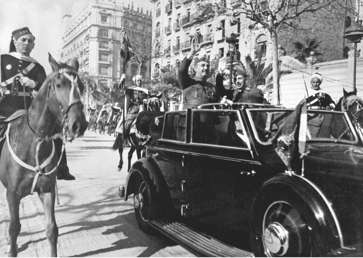 Francisco Franco encabeza, a bordo de un descapotable por la avenida de la Diagonal, el Desfile de la Victoria del 21 de febrero de 1939. A su derecha, el general y ministro de la Guerra del bando nacional Fidel Dávila. 