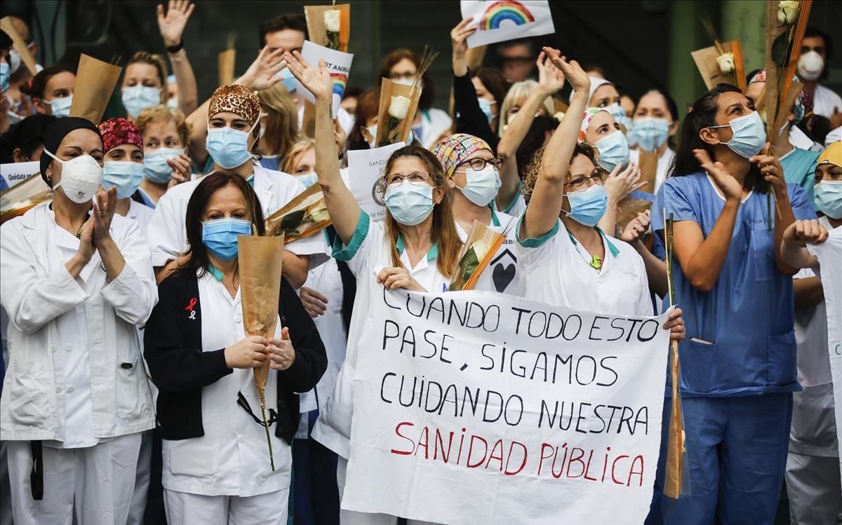 Personal sanitario del Hospital Clínic saludando a la gente que les aplaude desde la calle y balcones, a las 20h el día de Sant Jordi Personal sanitario del Hospital Clínic saludando a la gente que les aplaude desde la calle y balcones, a las 20h el día de Sant Jordi