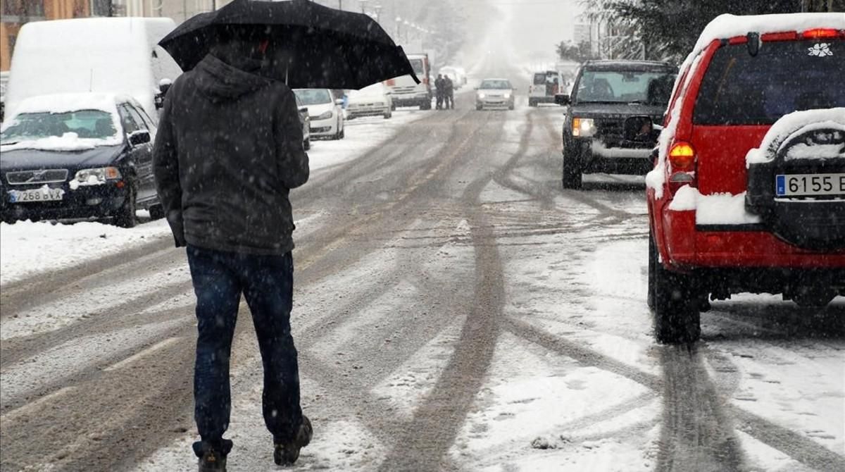 Un hombre se protege de la nieve con un paraguas en Esterri d’Àneu (Pallars Sobirà), en una nevada en el 2013. Un hombre se protege de la nieve con un paraguas en Esterri d’Àneu (Pallars Sobirà), en una nevada en el 2013.