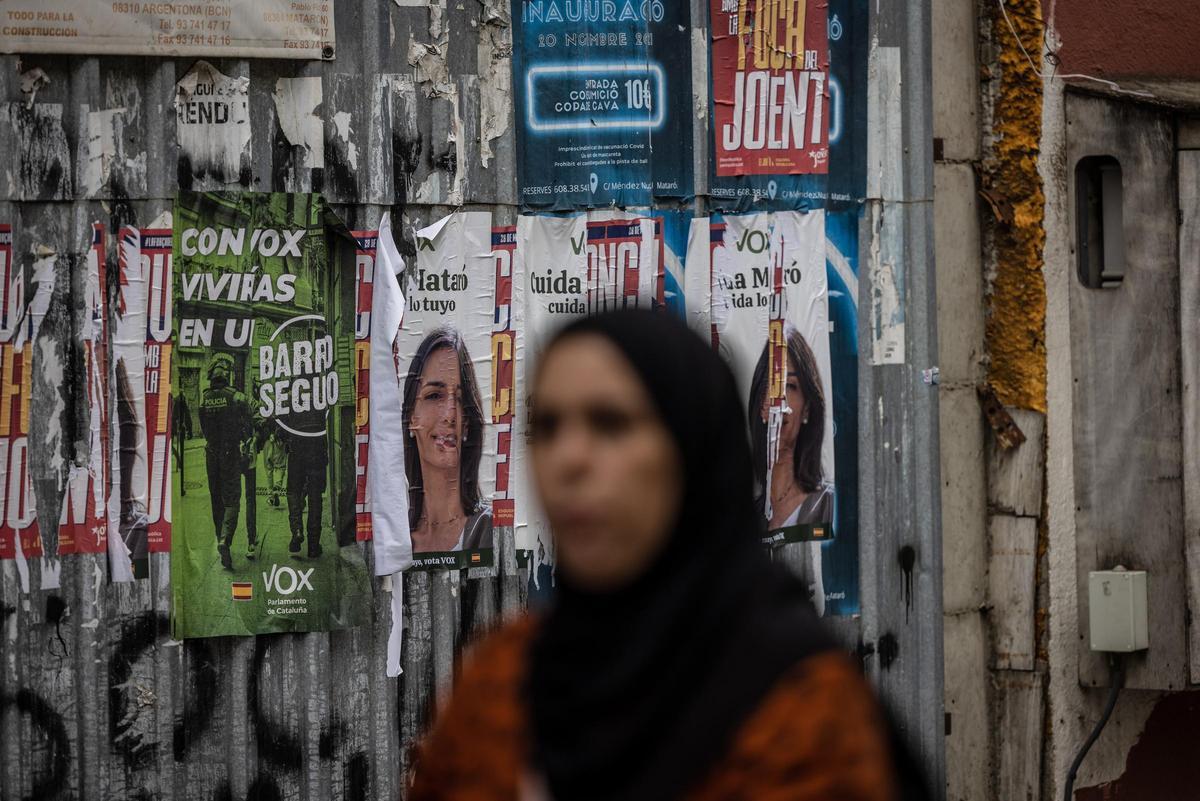 Una vecina marroquí pasa frente a propaganda electoral de Vox en el barrio de Cerdanyola, su granero de votos en Mataró. Una vecina marroquí pasa frente a propaganda electoral de Vox en el barrio de Cerdanyola, su granero de votos en Mataró.