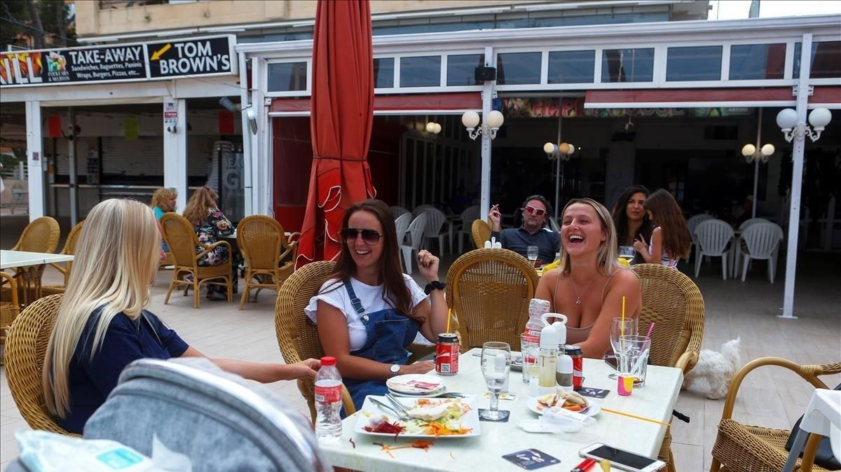 Jóvenes almuerzan en una terraza playera. Jóvenes almuerzan en una terraza playera.