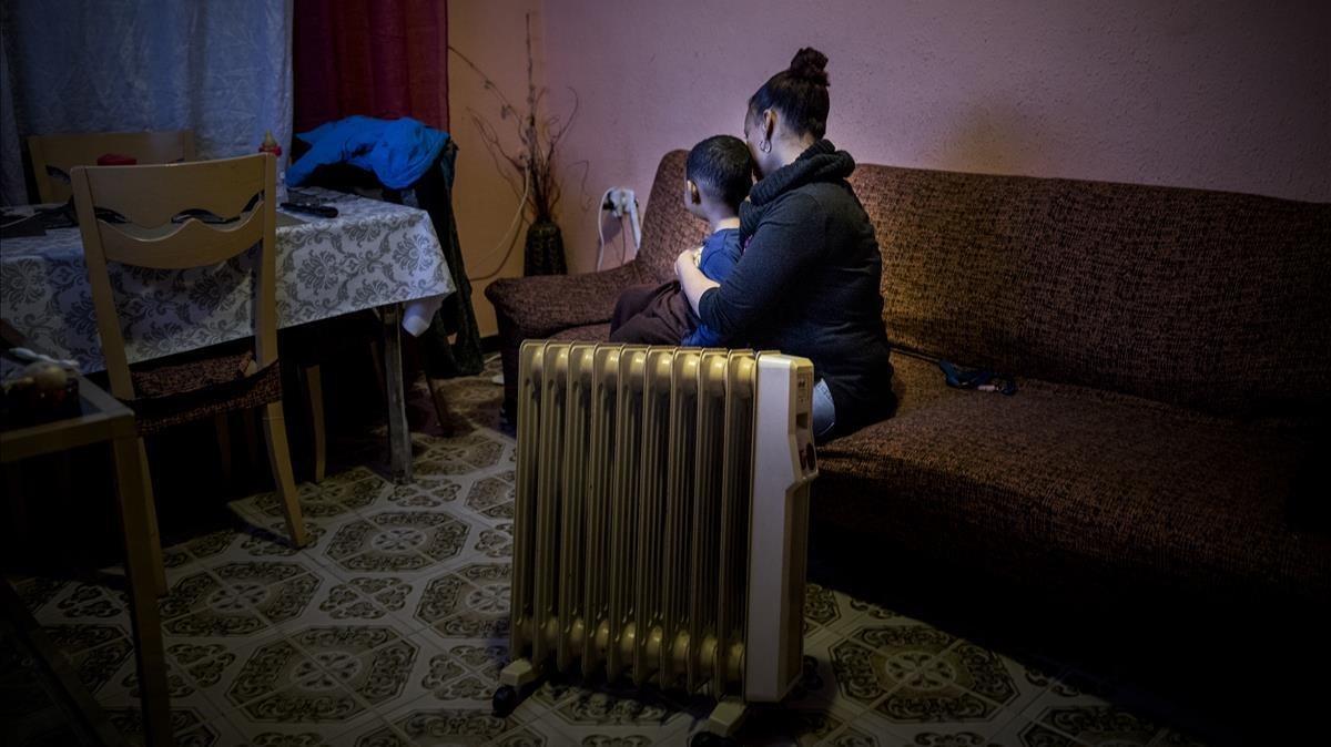 Una dona amb un dels seus fills, víctimes de la pobresa energètica, al seu pis de Barcelona. Una dona amb un dels seus fills, víctimes de la pobresa energètica, al seu pis de Barcelona.
