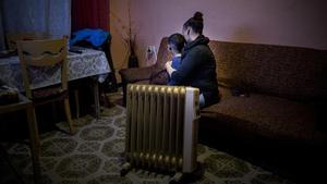 Una mujer con uno de sus hijos, víctimas de la pobreza energética, en su piso de Barcelona.