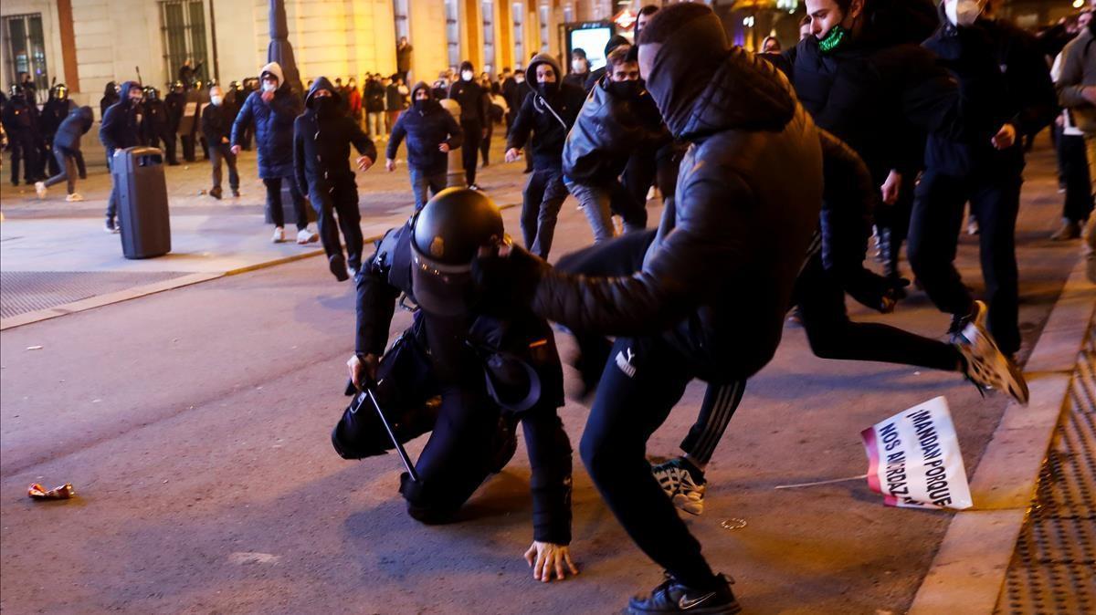 Los manifestantes patean a un agente de policía en Madrid.