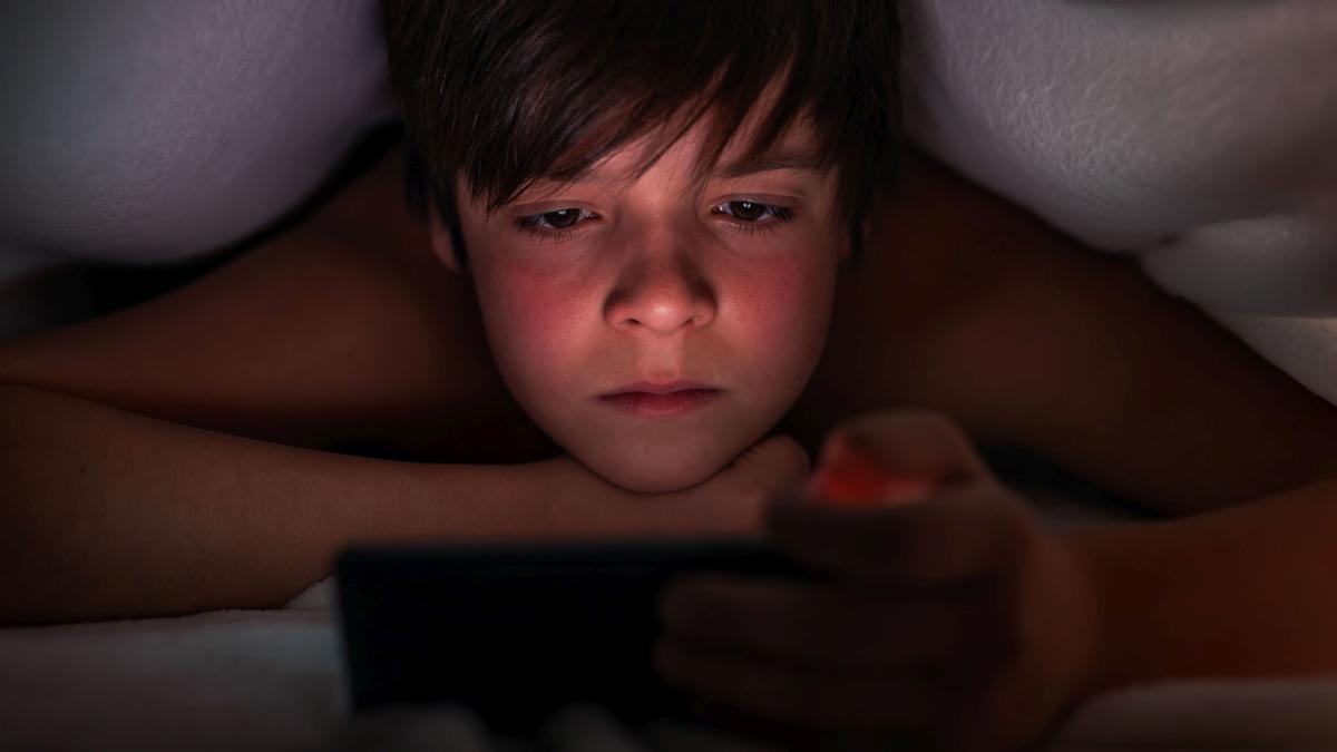 Un niño visualizando contenidos por la noche. 