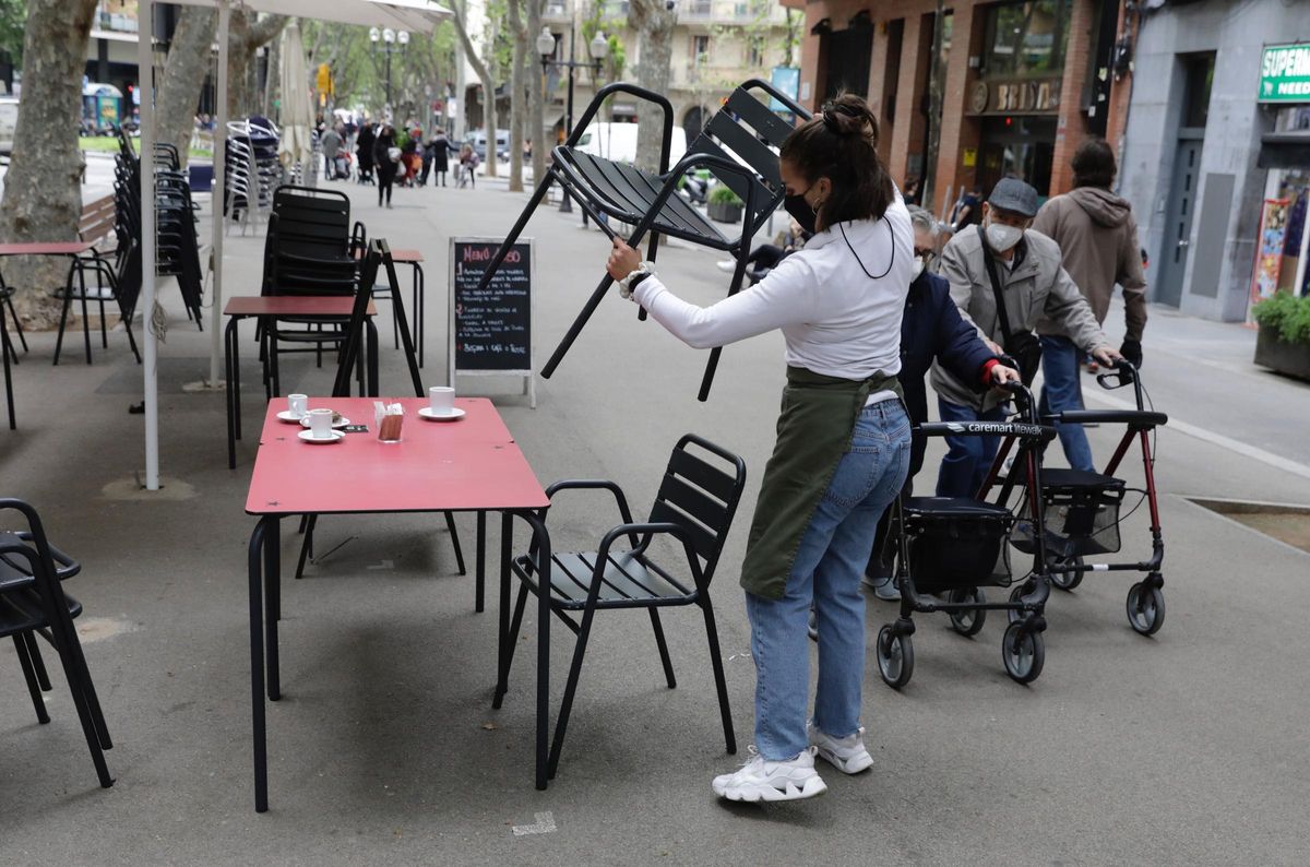Una mujer organiza la terraza del bar en el que trabaja, en la rambla del Poblenou. Una mujer organiza la terraza del bar en el que trabaja, en la rambla del Poblenou.