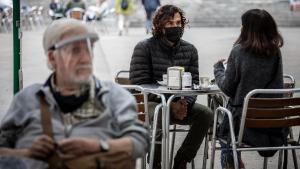 Un hombre lleva mascarilla en la terraza de un bar, en Barcelona. 
