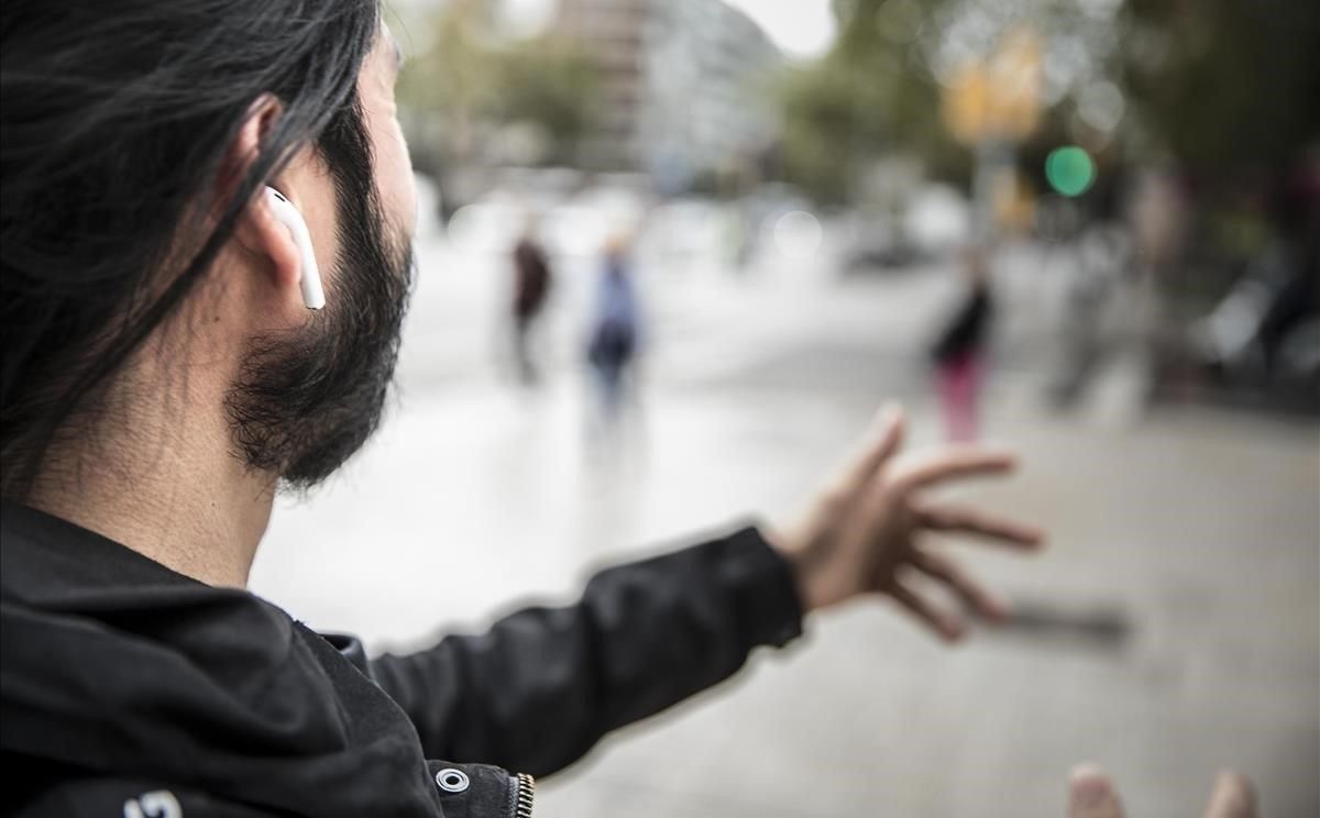 Un hombre con auriculares en las orejas, por las calles de Barcelona. Un hombre con auriculares en las orejas, por las calles de Barcelona.