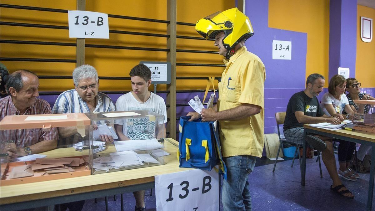 Un empleado de Correos entrega los votos por correo en el colegio electoral de la escuela Santa Marta, en L’Hospitalet, en las elecciones generales del 2016.