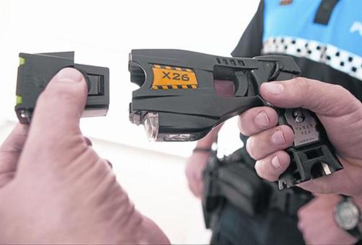 Un policía local de Sant Andreu de Llavaneres muestra una pistola eléctrica. Un policía local de Sant Andreu de Llavaneres muestra una pistola eléctrica.
