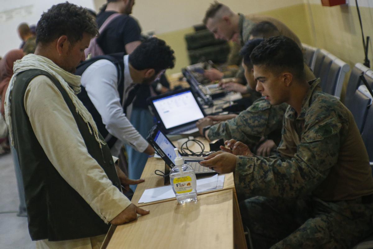 Militares norteamericanos controlan documentación de refugiados afganos en el aeropuerto de Kabul.