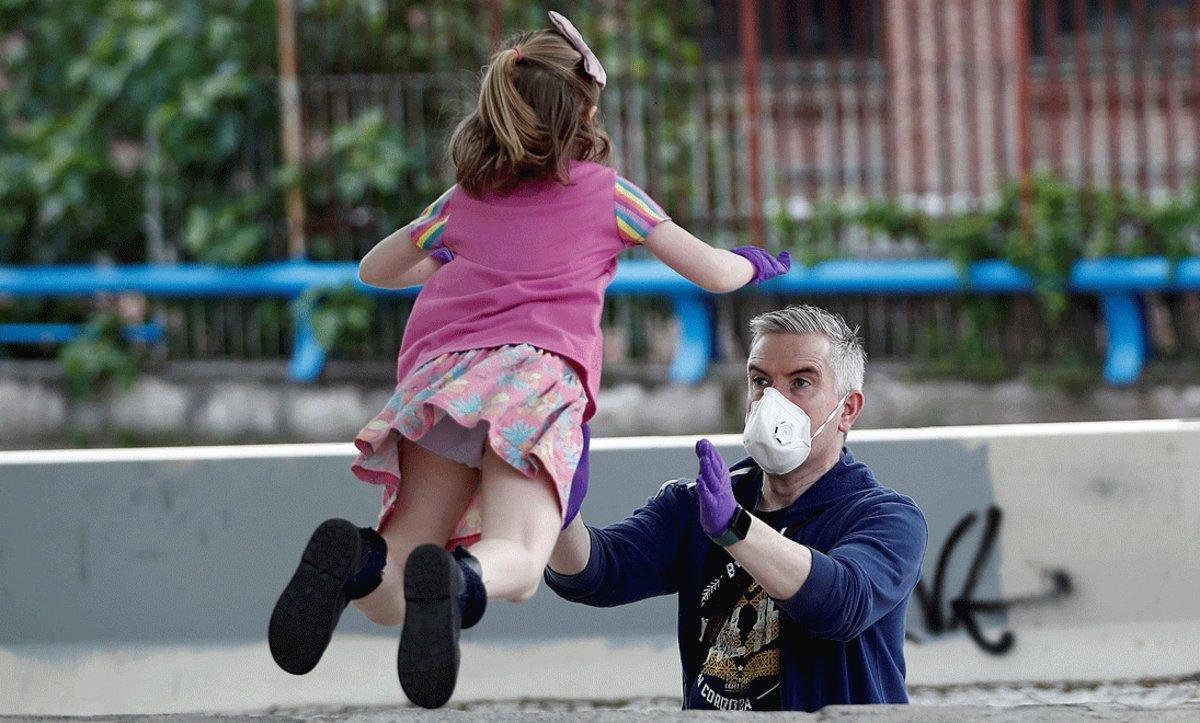 Un hombre juega con su hija en Madrid, el domingo 26 de abril, primer día en que se permite salir a pasear a los menores de 14 años.