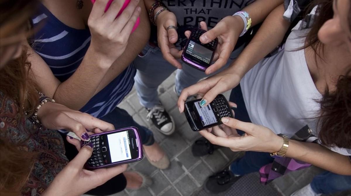 Estudiantes de secundaria con sus móviles.