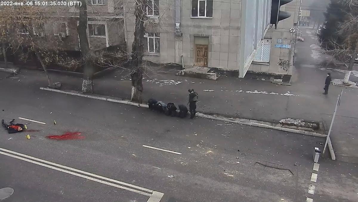 Un cuerpo yace en el suelo junto a un charco de sangre mientras un oficial kazajo apunta contra cuatro arrestados, en un vídeo difundido por el Gobierno este jueves.