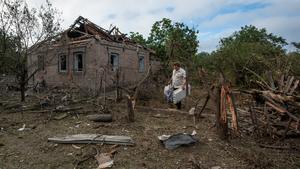Un residente lleva objetos recuperados de una casa dañada por un ataque ruso con misiles en la localidad de Kramatorsk.