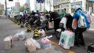 Repartidores de distintas compañías preparan sus paquetes en Pekín, el pasado martes.