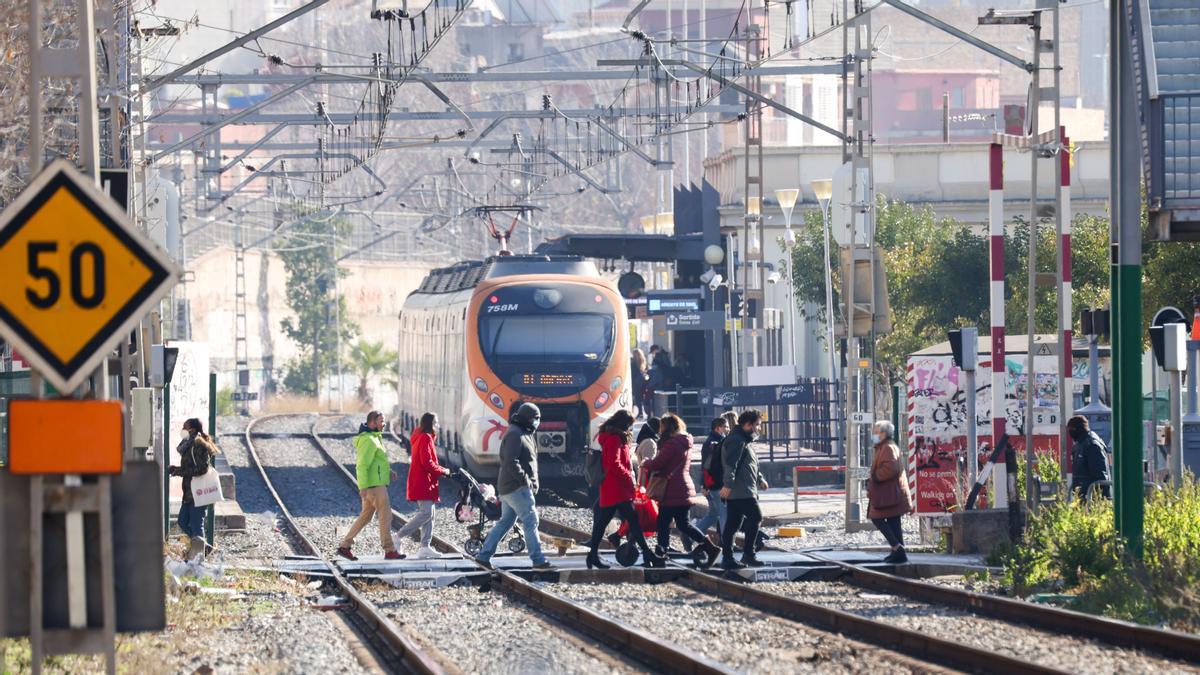 Vecinos cruzando el paso a nivel sobre la vía del tren en Sant Feliu, este viernes.
