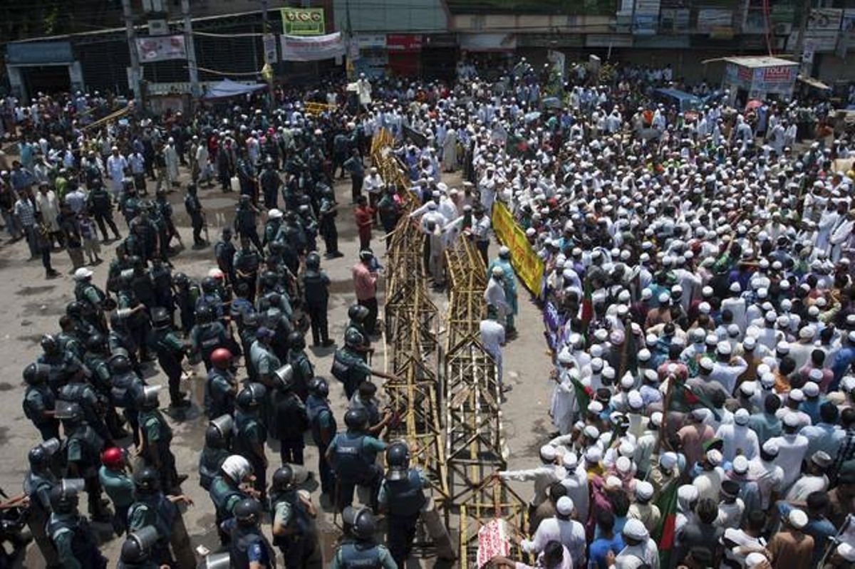 Cientos de islamistas, a la derecha, que bloquean una calle en Dacca, se enfrentran a la policía, el domingo. Cientos de islamistas, a la derecha, que bloquean una calle en Dacca, se enfrentran a la policía, el domingo.
